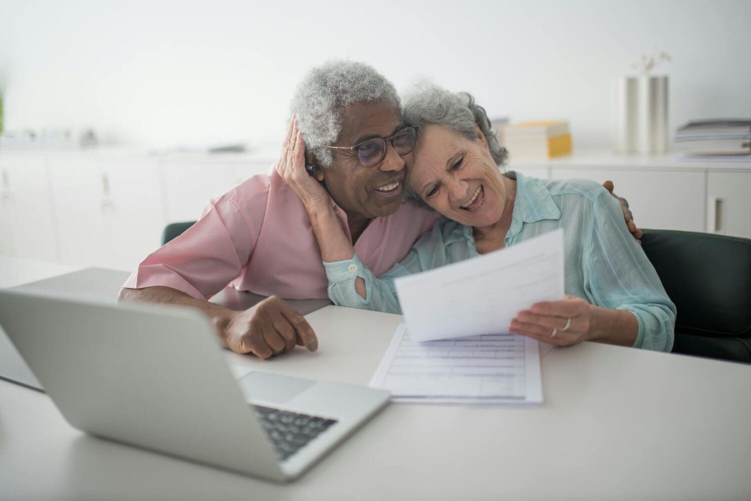 Smiling couple reviewing life insurance payout paperwork together at home in Arkansas