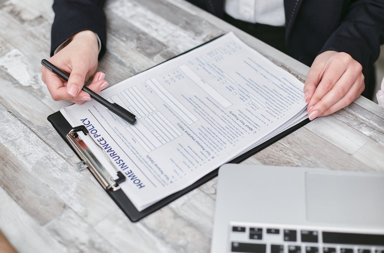 Insurance agent helping client fill out a home insurance claim form.