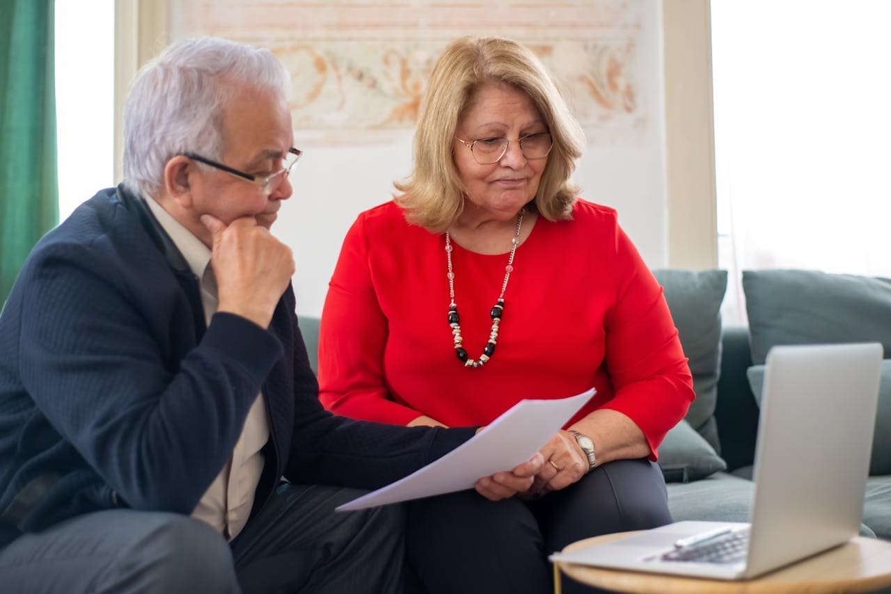 A couple sitting with paperwork reviewing different insurance plans together